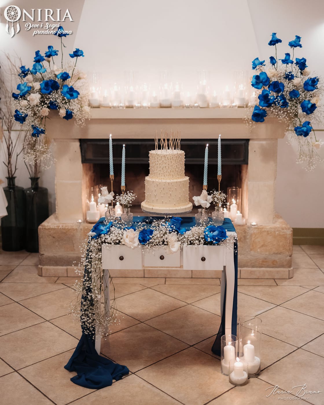 Camino allestito con torta, candele e fiori per un evento privato firmato Oniria
