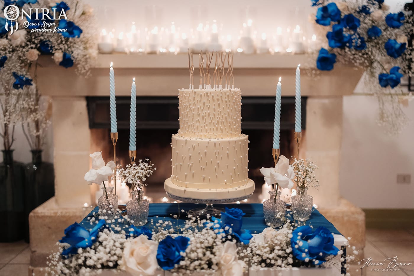 Torta allestita con candele e rose blu per un evento privato firmato Oniria